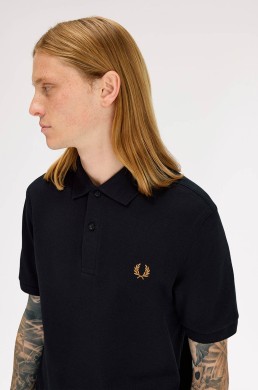 Detalle corona laurel color caramelo polo negro Fred Perry hombre