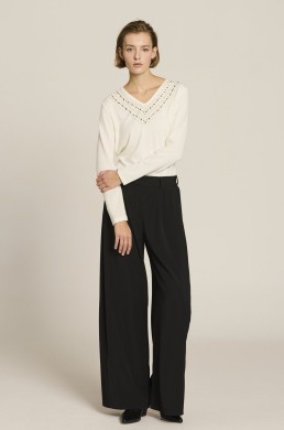 Look Jersey crudo con abalorios Escorpion y pantalón negro